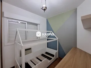 Foto interna de um quarto com uma cama de beliche branca e paredes em tons claros.