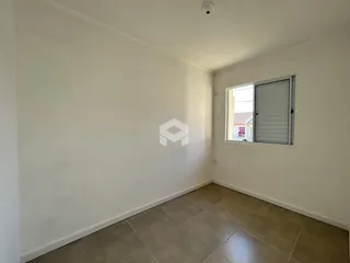Vista interna de um ambiente com paredes brancas e piso de cerâmica.