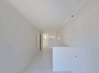 Corredor interno de uma residência branca com piso de cerâmica.