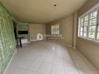 Vista de um corredor interno com piso de cerâmica clara e paredes em tom neutro.