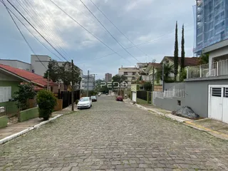 Vista da rua pavimentada de paralelepípedos em uma área residencial.