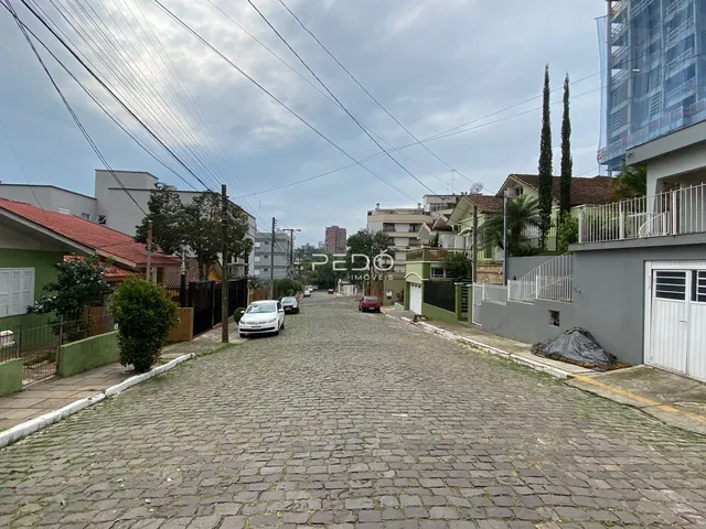 Vista da rua pavimentada de paralelepípedos em uma área residencial.