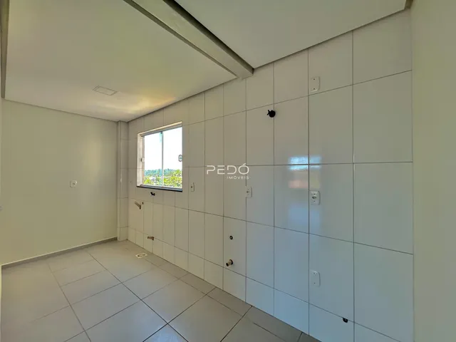 Hall de entrada com piso de cerâmica e paredes brancas.
