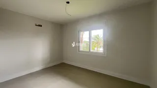 Foto de um ambiente interno com paredes brancas e piso claro.
