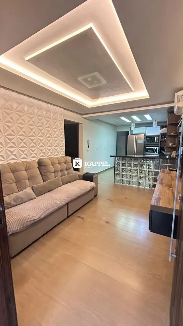 Sala de estar com sofá e piso de madeira clara.