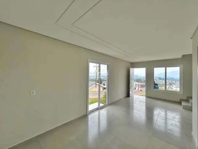 Sala de estar com piso de cerâmica e porta de vidro que dá para a vista.
