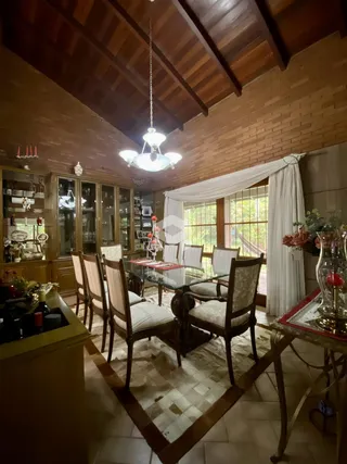 Uma sala de jantar com piso de madeira e teto de madeira aparente.