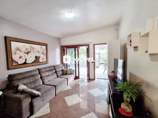 Sala de estar com sofá grande e piso de cerâmica.