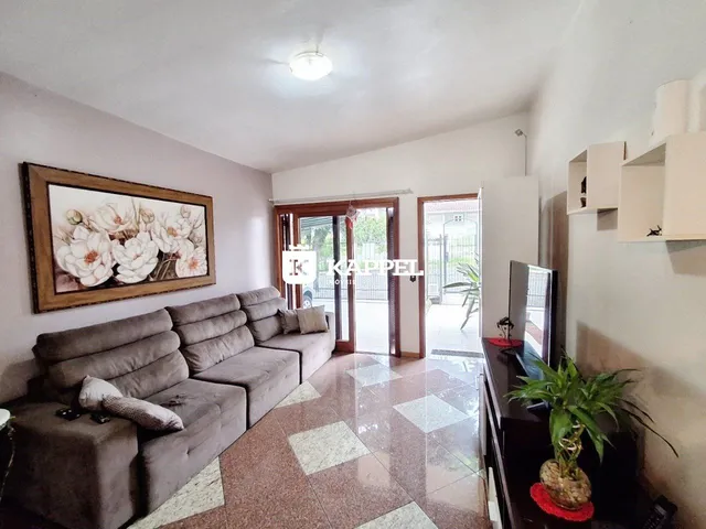 Sala de estar com sofá grande e piso de cerâmica.
