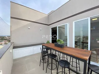 Vista externa de uma área de lazer com mesa e cadeiras em uma residência.