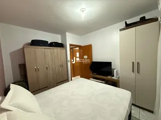 Quarto com armários de madeira e cama.