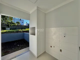 Vista de um interior que se abre para um pátio externo com área verde.