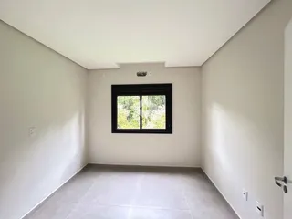 Ambiente interno com paredes brancas e piso de cerâmica.