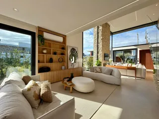 Sala de estar moderna com sofá e estantes de madeira clara.
