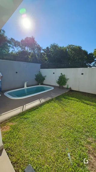 Foto de uma piscina e jardim em uma propriedade.
