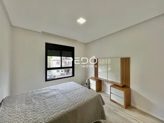 Quarto com cama grande em ambiente claro.