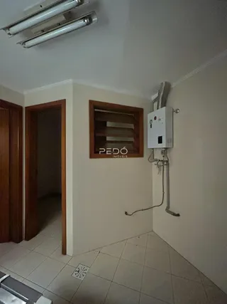Vista de um corredor interno com portas de madeira e um nicho decorativo.