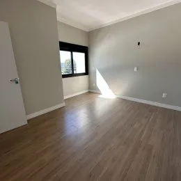 Ambiente interno com piso de madeira e janela visível.