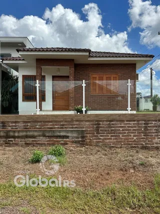 Fachada de casa em tijolo aparente com porta de madeira.