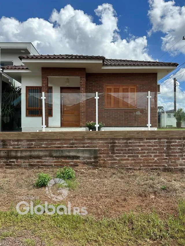 Fachada de casa em tijolo aparente com porta de madeira.