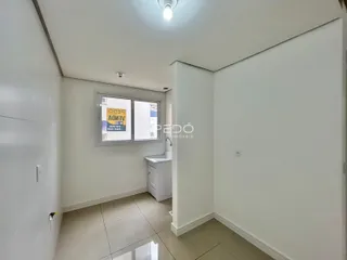 Vista de um corredor interno com piso de cerâmica e paredes brancas.