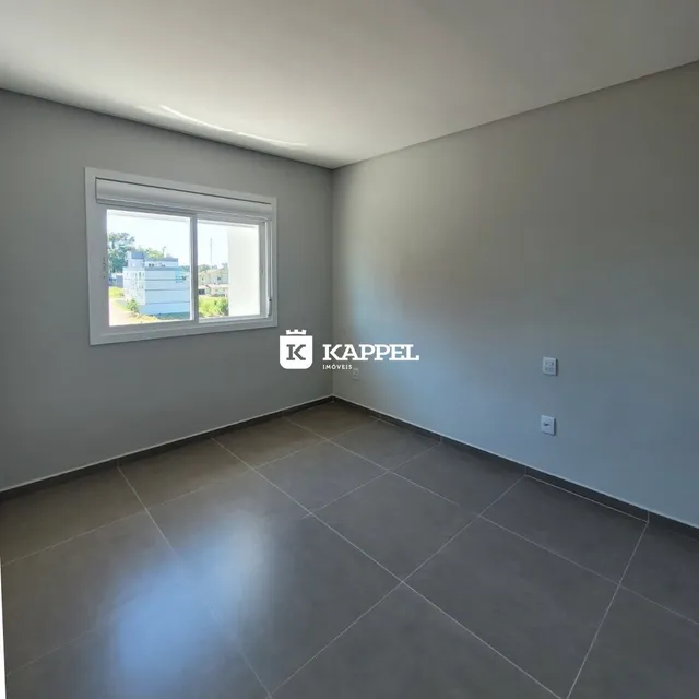 Foto de um cômodo interno com piso de porcelanato e janela.