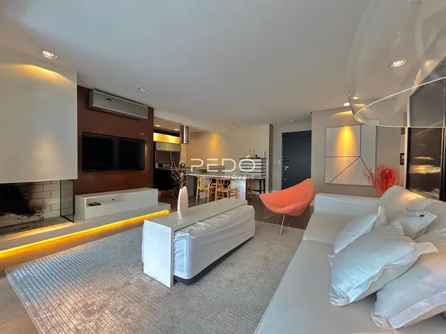 Sala de estar moderna com lareira e sofá branco em um apartamento.