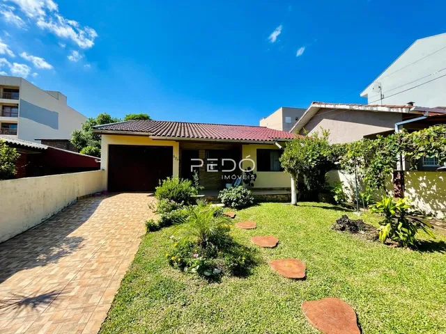 Vista externa de uma residência com jardim e entrada de garagem em Lajeado.