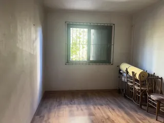 Foto de uma sala com piso de madeira e uma grande janela com vista para o exterior.