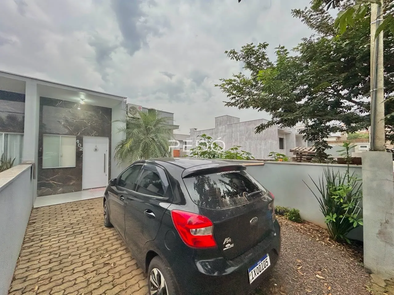 Fachada de uma residência em Lajeado, Brasil, com uma garagem e entrada pavimentada.