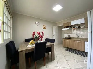 Foto de uma sala de jantar com mesa de madeira.
