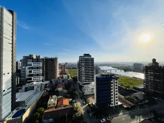 Vista aérea de uma área urbana com edifícios e um corpo d'água ao fundo.
