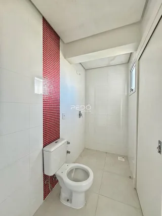 Foto de um banheiro com revestimento de tijolos vermelhos e brancos.