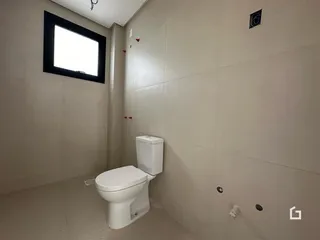 Corredor interno com paredes brancas e um vaso sanitário.