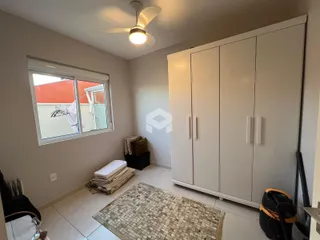Quarto com janela e armário branco na sala.