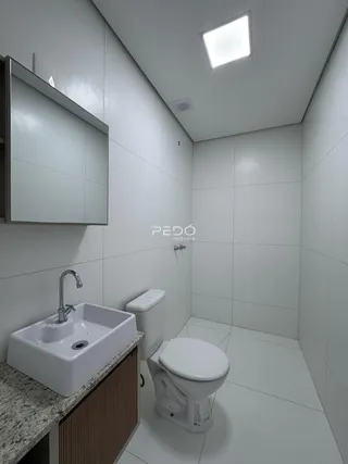 Foto de um banheiro moderno com revestimento cerâmico branco.