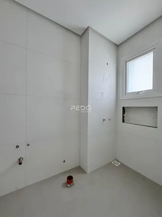 Interior de um ambiente com paredes brancas e piso cinza claro.