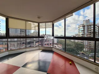Vista ampla de um ambiente interno com piso colorido e grandes janelas.