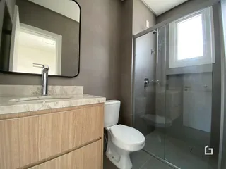 Foto de um banheiro moderno com box de vidro e bancada de mármore.