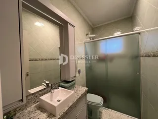 Banheiro com box de vidro e pia.