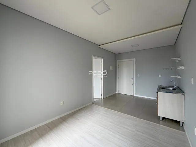 Interior de um ambiente com paredes cinzas e piso claro.