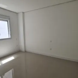 Vista interna de um cômodo vazio com paredes brancas.