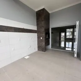 Foto de um corredor interno com paredes em tons de cinza e detalhes em marrom.