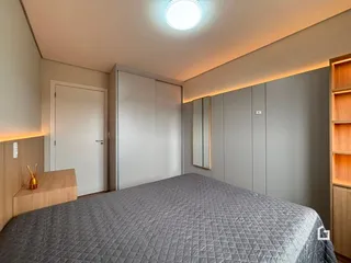 Quarto com cama e armários em um ambiente claro.