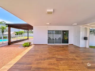 Interior de uma sala de estar com piso de madeira e acesso ao exterior.