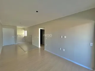 Hall de entrada de uma residência com piso de madeira clara.