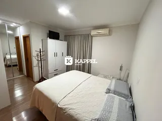 Quarto com cama e guarda-roupa branco em um imóvel.