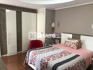 Um quarto com cama e piso de madeira.
