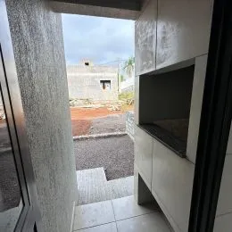 Foto de um corredor interno com parede clara e porta.