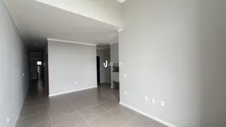 Corredor interno de uma residência com paredes brancas e piso de cerâmica.